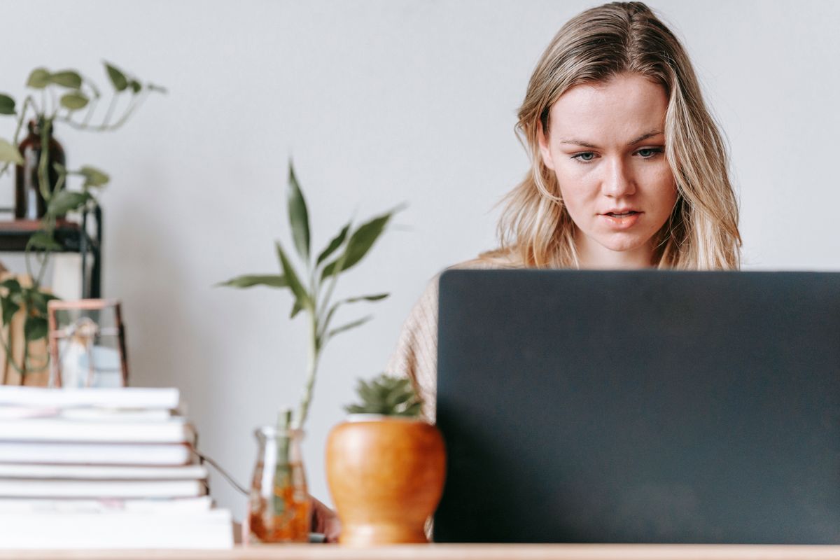 A freelancer building workflows on a laptop at a bright home office desk