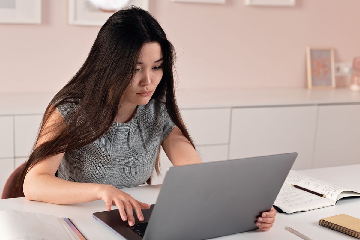 A woman working from home on a laptop, running a freelance automation business