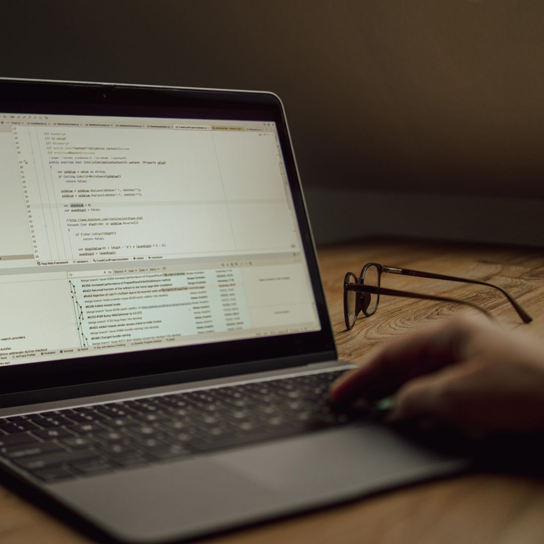 Person working on programming code on a laptop indoors