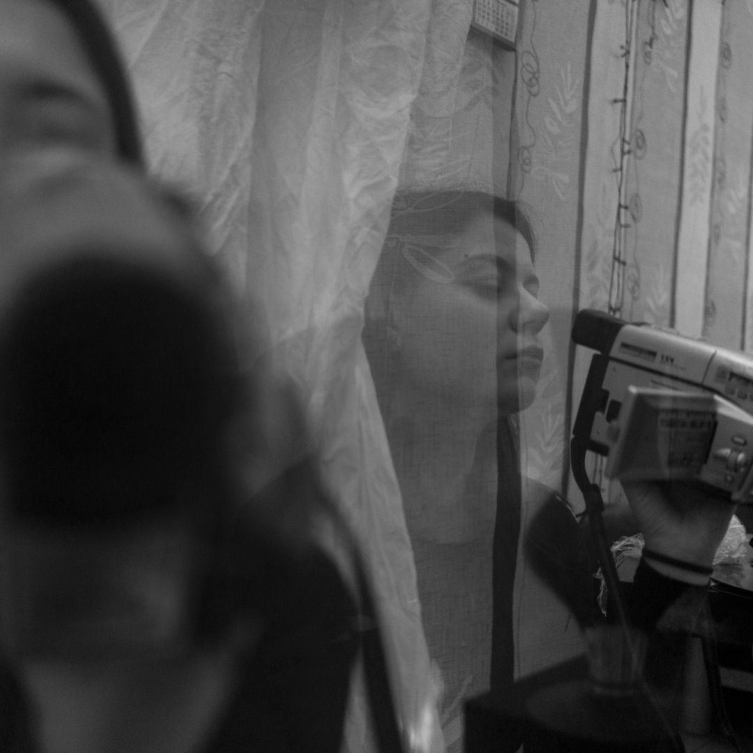 Young woman filming a video blog on camera in a home studio