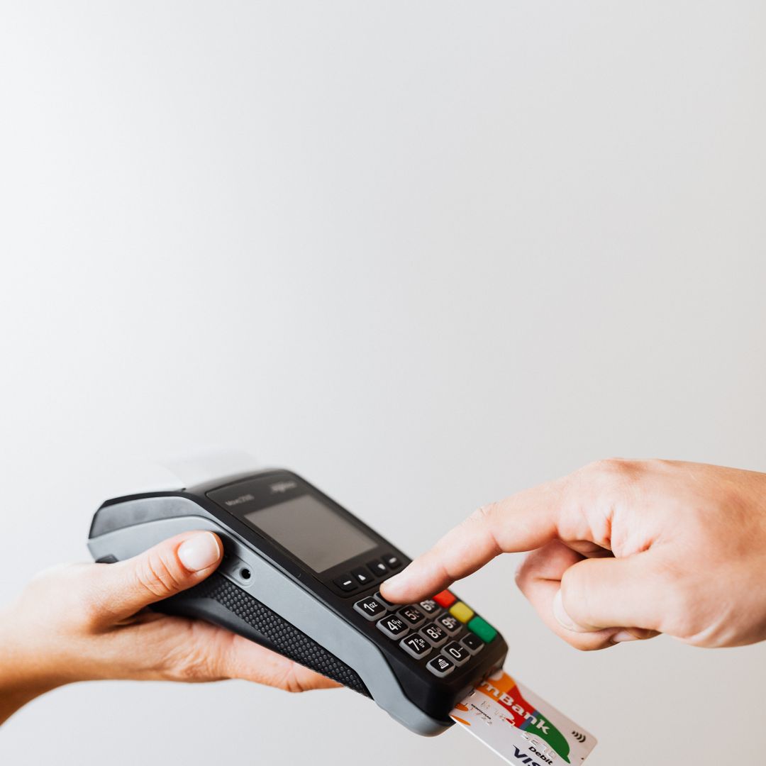 Person entering a PIN on a payment terminal keypad
