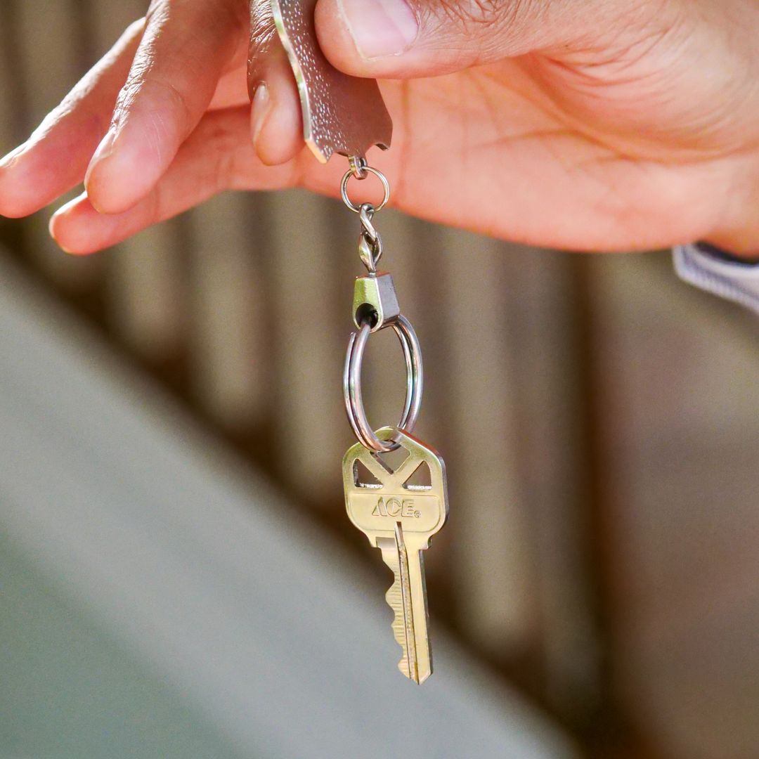 Close-up of a hand holding a house key to a new rental property