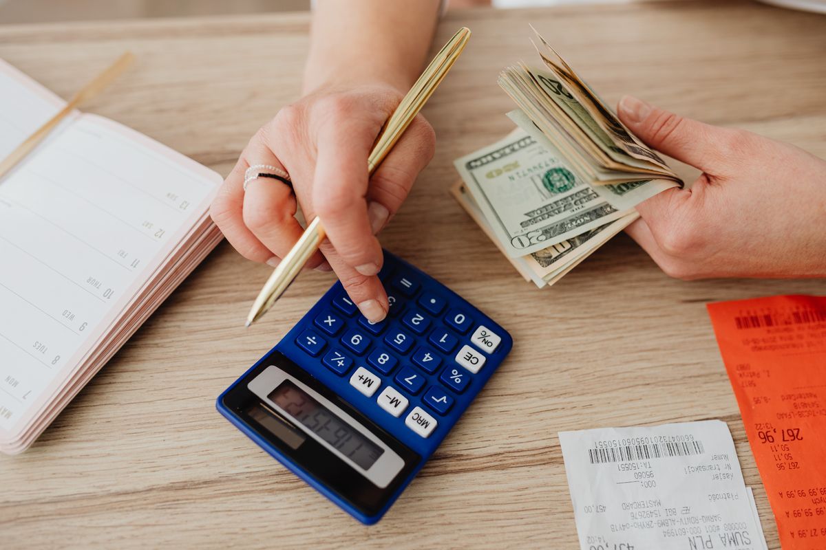 Woman calculating money and receipts with a calculator