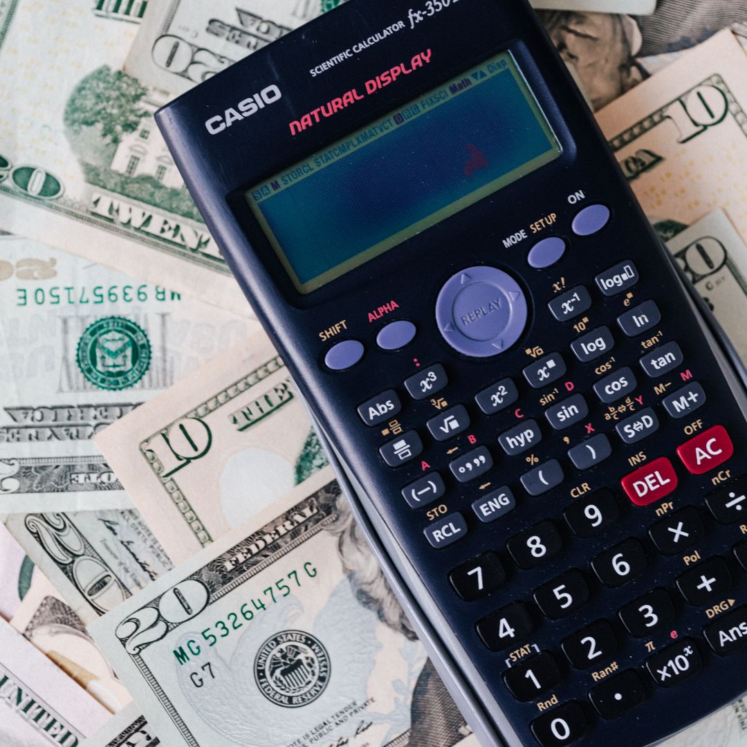 Calculator placed over a stack of US dollar bills