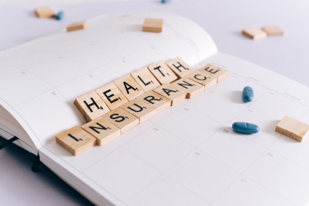 Close-up of health insurance letter tiles on an open planner