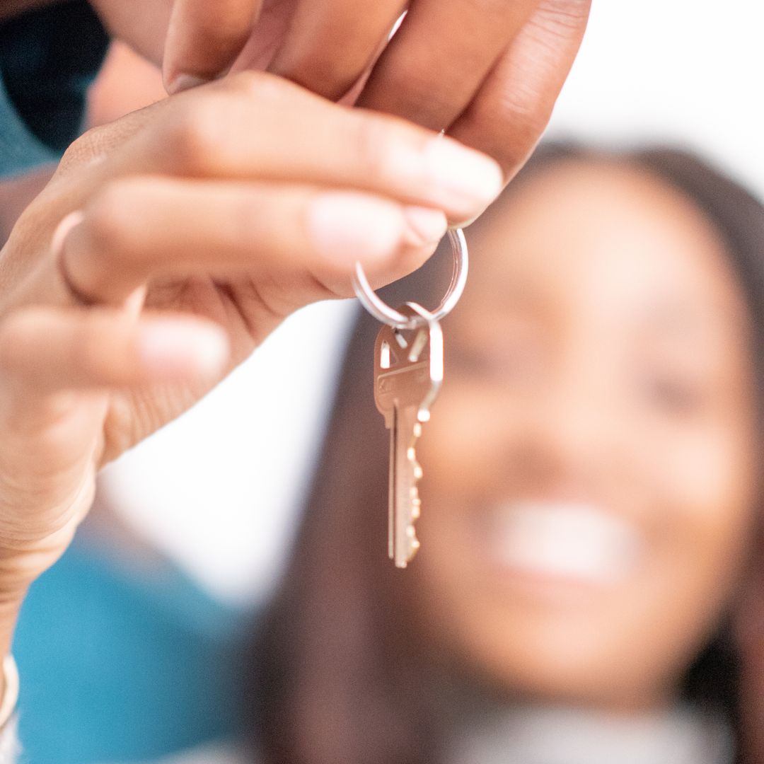 New homeowners receiving keys to their house, joyful