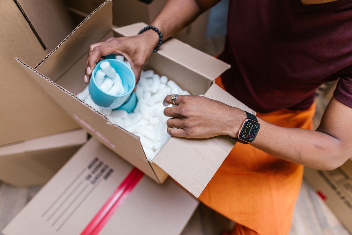 A warehouse worker packing cardboard shipping boxes for e-commerce orders
