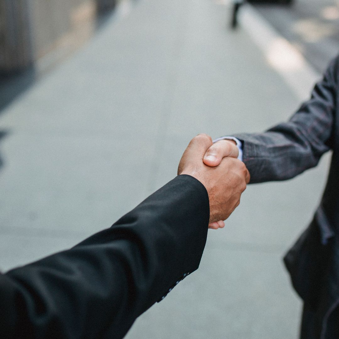 Two businessmen shaking hands outside
