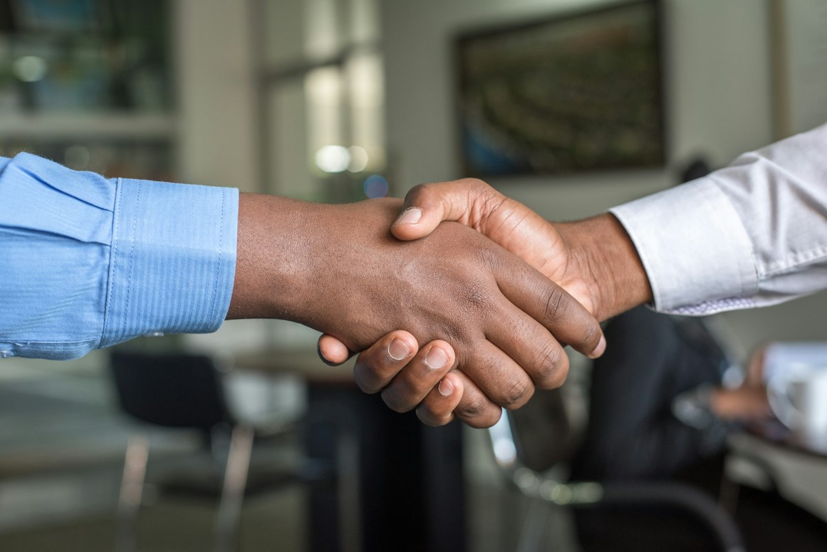 Two professionals shaking hands after successful salary negotiation