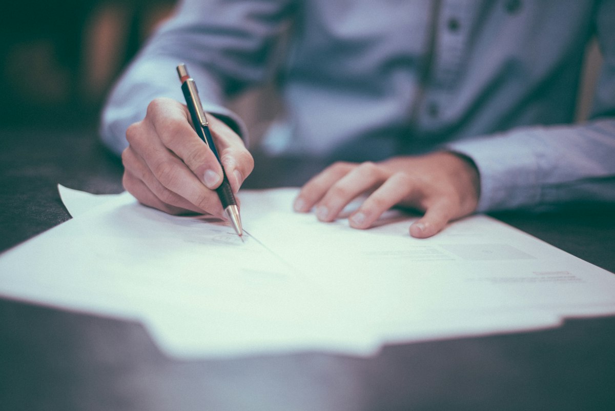 Signing a job contract with a pen on official documents