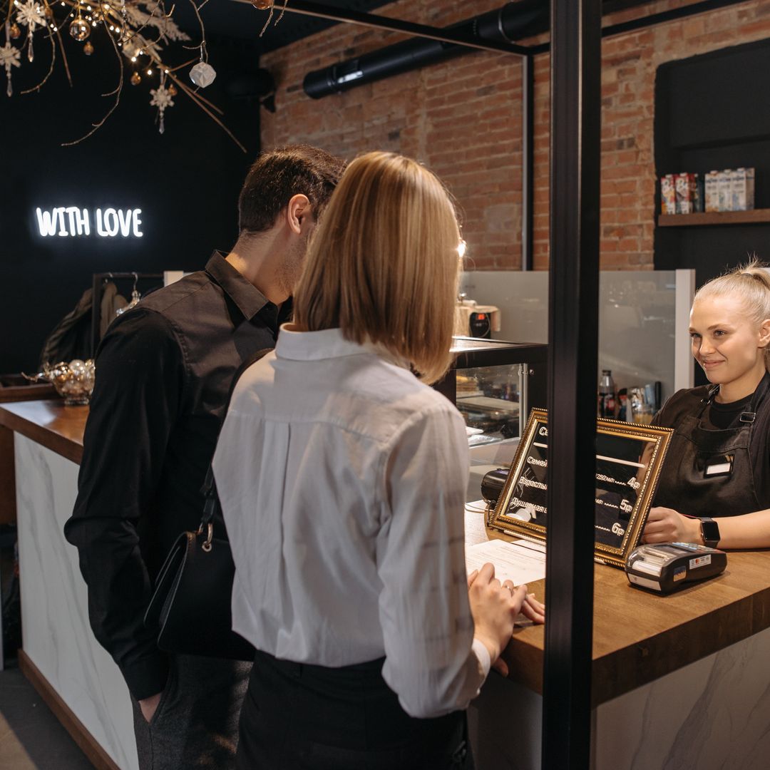 A cafe owner behind the counter of their small cafe