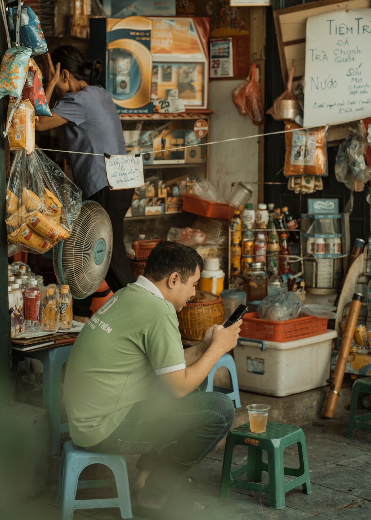Shopkeeper at a store counter using his phone