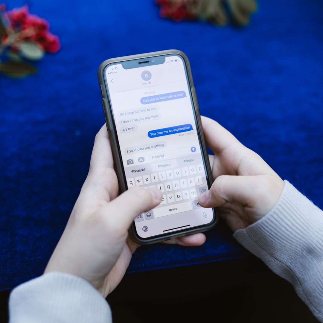 Hands typing a message on a smartphone