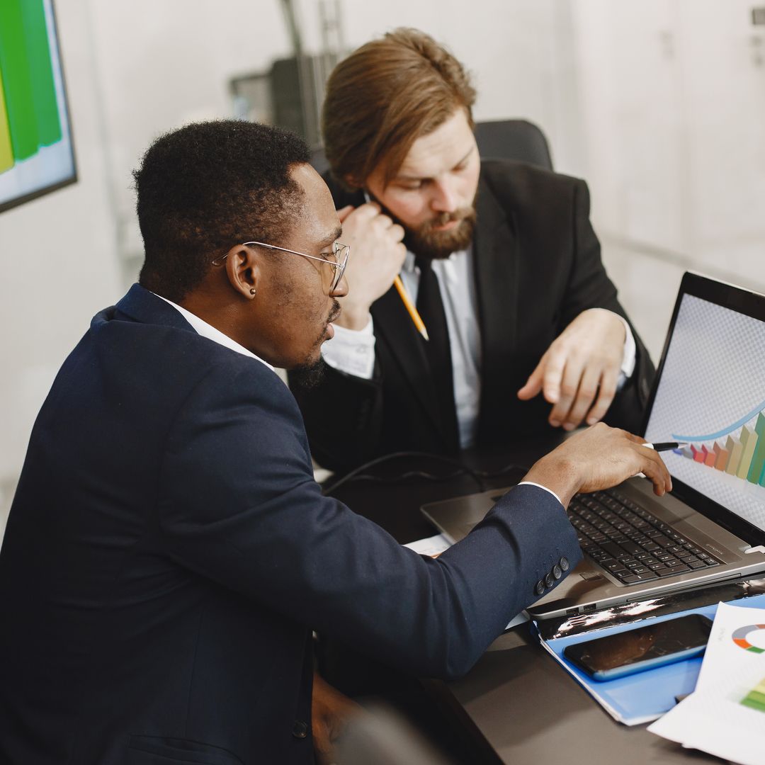 Two professionals reviewing growth charts on a laptop in an office